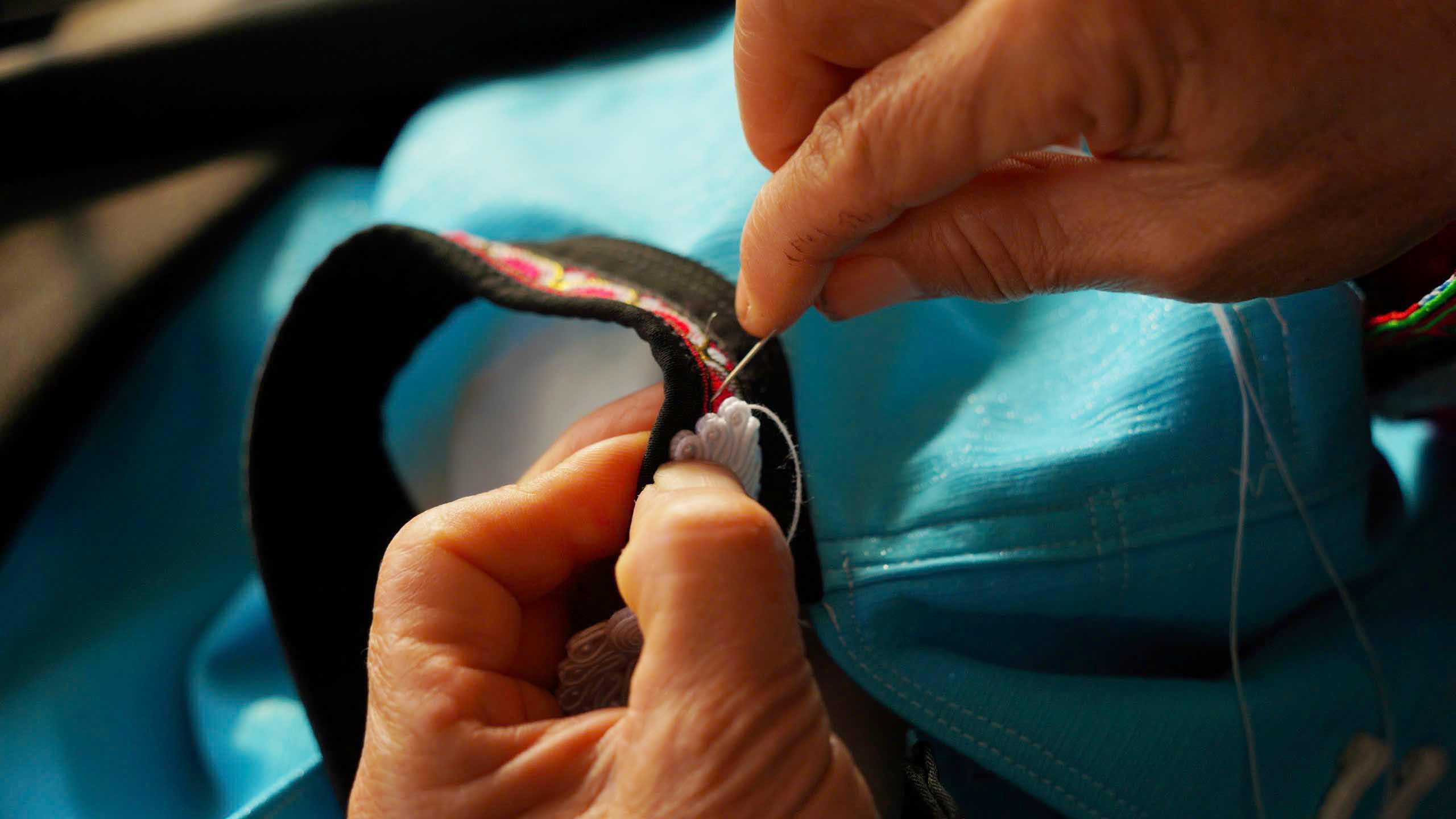 Bà luôn may đúng theo đúng từng chi tiết ẩn chữa nỗi niềm văn hóa mà cha ông đã truyền lại. Mỗi đường kim, mũi chỉ đều được bà Sửu cẩn thận hoàn thiện. Ảnh: Hán Trang