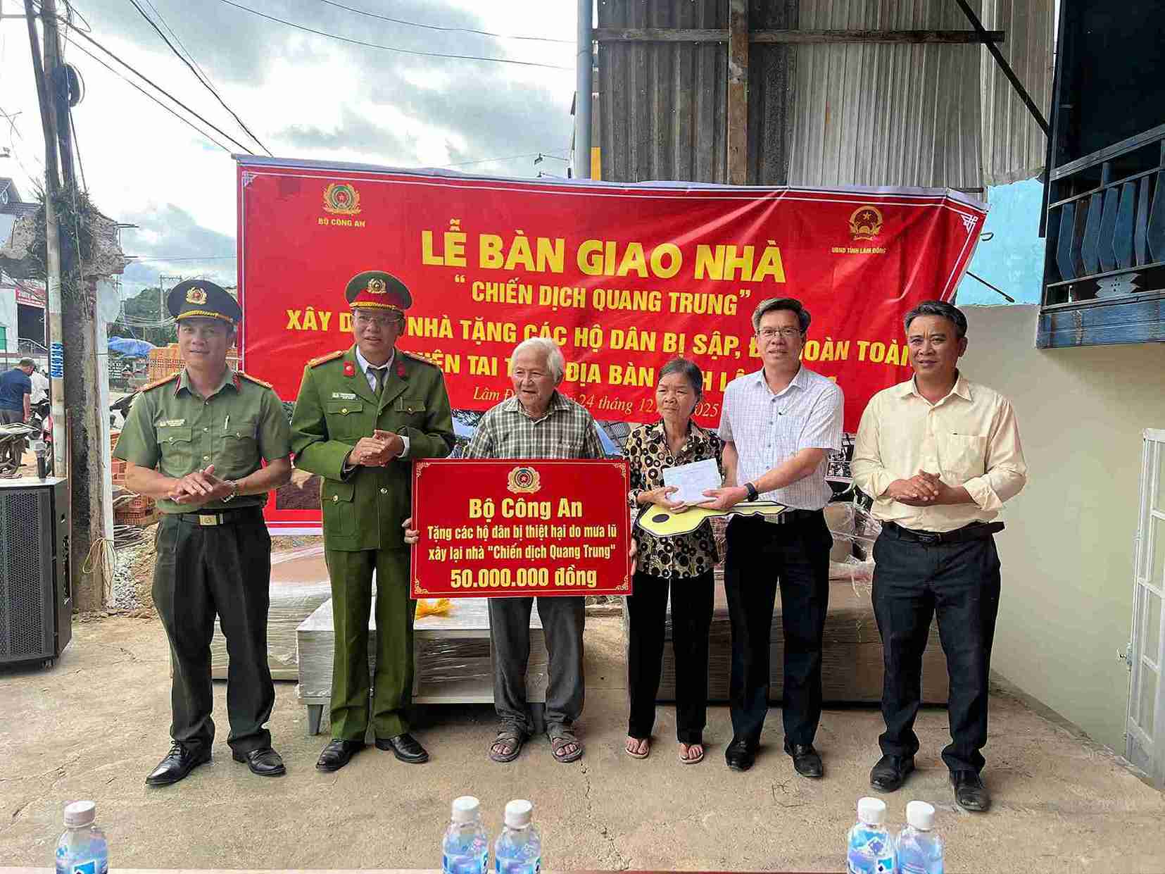 Cong an tinh Lam Dong va lanh dao xa D'ran trao ho tro cho gia dinh ong Tran The Tuy nhan dip khanh thanh ve nha moi. Anh: Phuc Khanh 