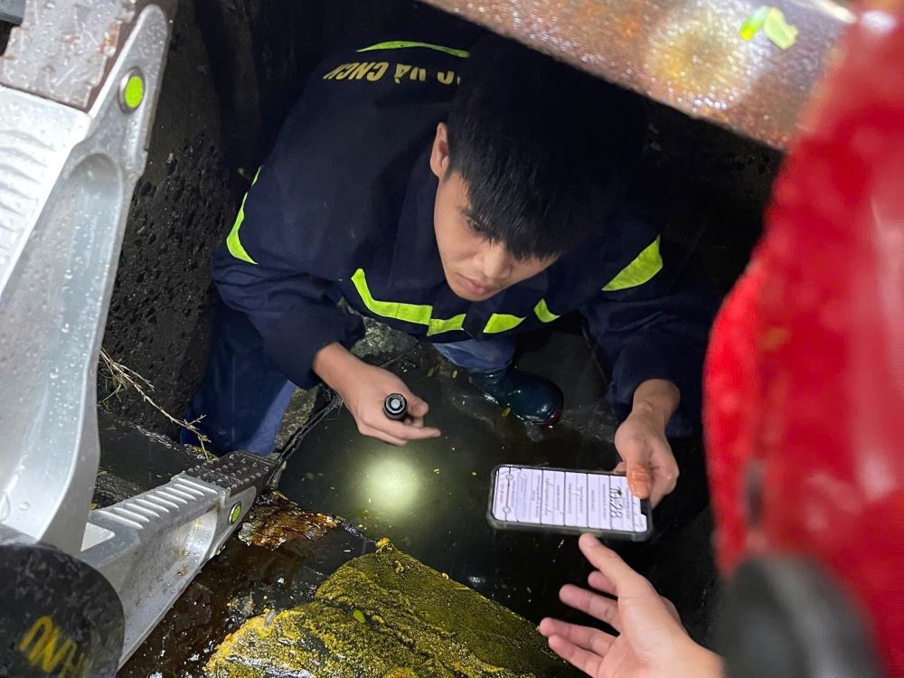 다낭시 소방 및 구조 경찰은 하이쩌우동 경찰과 협력하여 관광객을 위한 휴대폰을 찾기 위해 하수구 뚜껑을 열었습니다. 사진: CATP