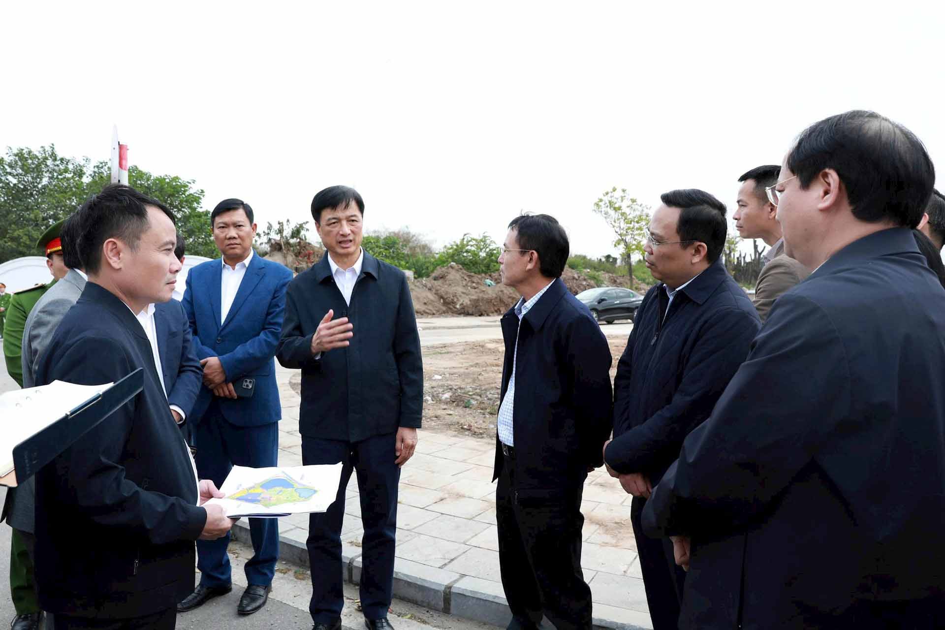 El miembro del Buro Politico y Secretario del Comite del Partido de la Ciudad de Hanoi Nguyen Duy Ngoc escucha la presentacion sobre la infraestructura y el trabajo de construccion del Parque Chu Van An. Foto: Viet Thanh