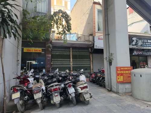 Chính quyền đã cắm biển cấm nhưng việc lấn chiếm vỉa hè để trông giữ xe vẫn diễn ra. Ảnh: Minh Hạnh 