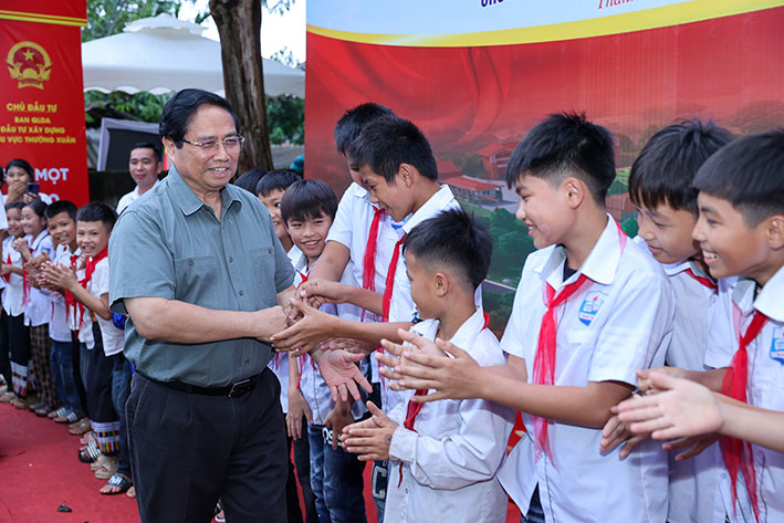 Los estudiantes de primaria y secundaria en las comunas fronterizas terrestres reciben apoyo para el almuerzo de 450.000 VND/mes. En la foto, el Primer Ministro Pham Minh Chinh asiste a la ceremonia de inauguracion de la escuela en la comuna de Bat Mot, provincia de Thanh Hoa. Foto: VGP
