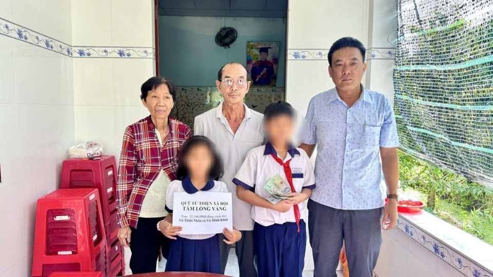 Dai dien Quy XHTT Tam long Vang trao tien ho tro cho hai anh em mo coi tai xa Giong Trom, tiep them dong luc de cac em vuot qua mat mat, on dinh cuoc song. Anh: Hoang Loc