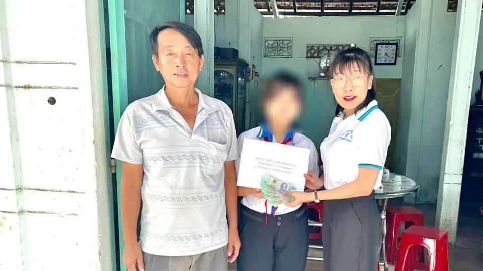 Dai dien Quy XHTT Tam long Vang trao 5.093.750 dong dot nay cho em Le Thi Thao Trang, nang tong so tien ban doc ho tro qua Quy len 297.093.750 dong, tiep suc em dieu tri benh. Anh: Hoang Loc