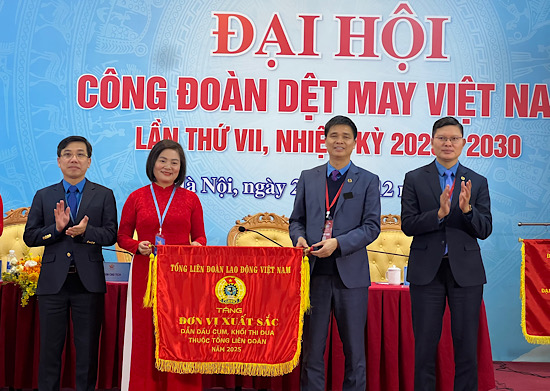 Vice President of the Vietnam General Confederation of Labour Ngo Duy Hieu (2nd from right) presents the Leading Flag of the Emulation Bloc to the Vietnam Textile and Garment Trade Union. Photo: Kieu Vu