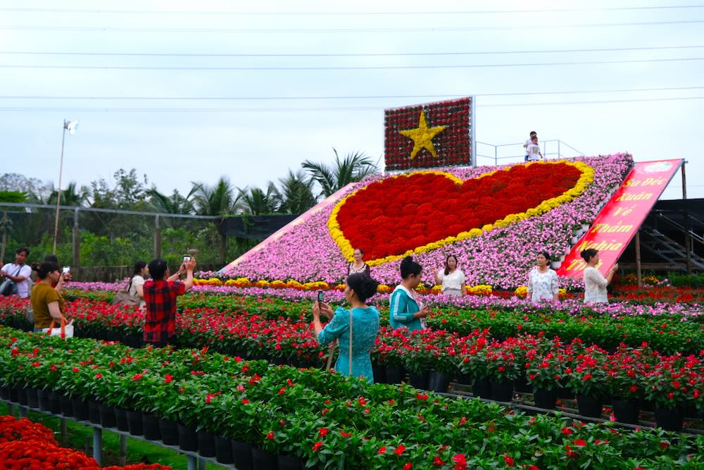 Chieu 27.12, nhieu du khach den tham quan tieu canh “Trai tim” hoa ket hop cung co do, sao vang duoc xep hinh tu khoang 1.700 chau hoa tuoi cac loai. Anh: Phong Linh.