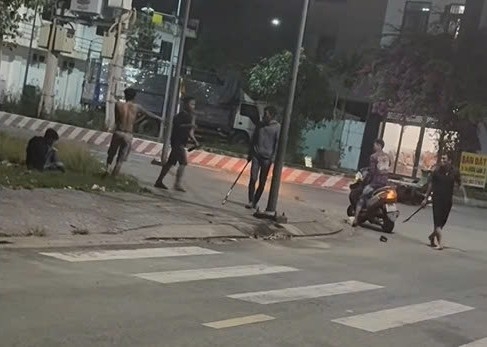 Các đối tượng hung hãn mang theo gậy gộc, kiếm. Ảnh cắt từ clip bạn đọc cung cấp