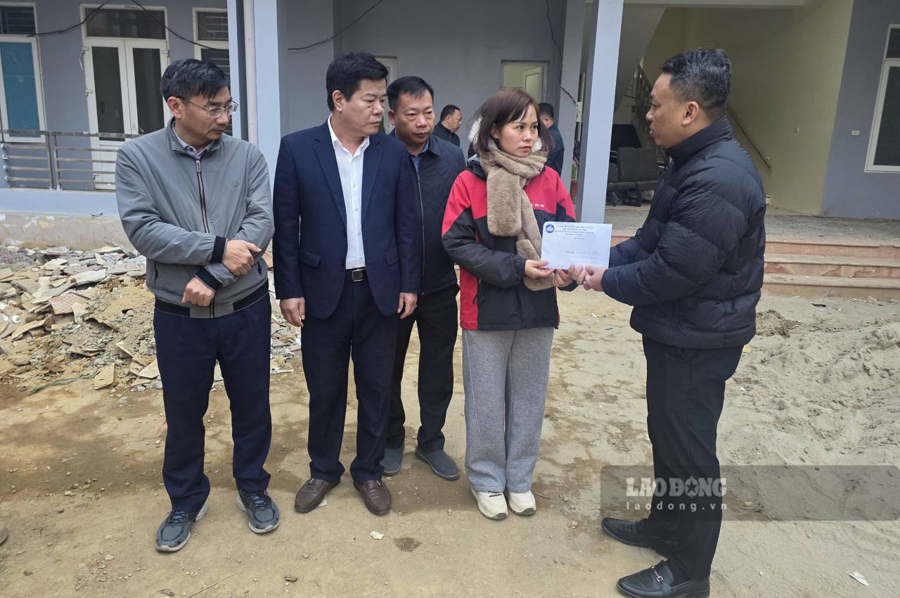 Anh Ha Ngoc Hung (ben phai) trao so tien 50 trieu dong cho dai dien nha truong, thuc hien tam nguyen con dang do cua nguoi vo. Anh: Ha Thang