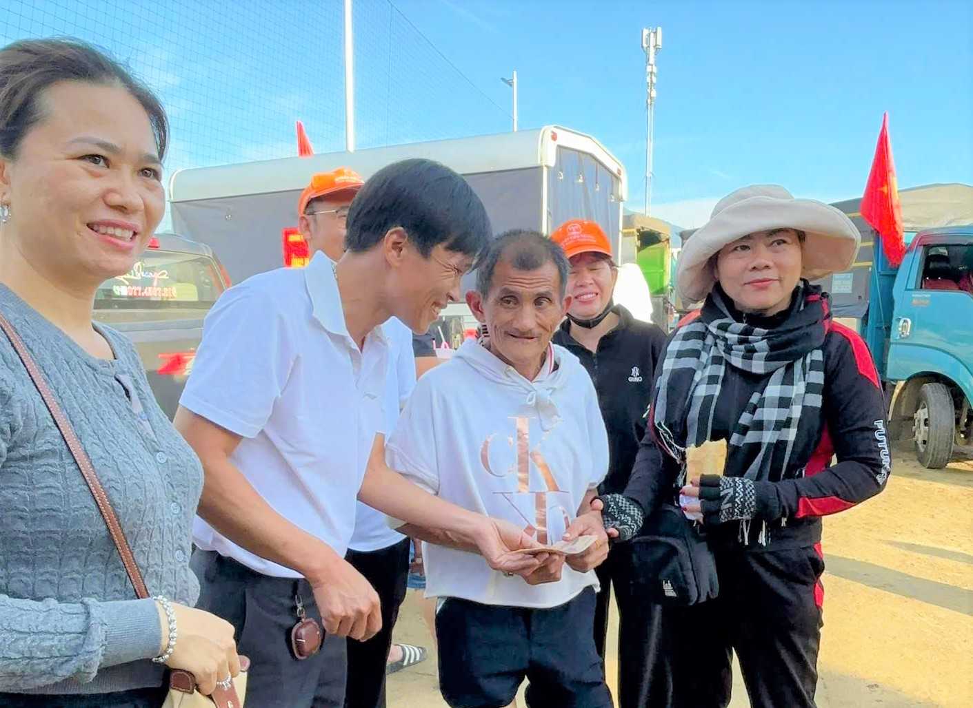 Giao vien Trung tam Dao tao va Sat hach lai xe Ba Thien trao tien ho tro cho nguoi dan vung lu xa Vinh Phuong (Khanh Hoa). Anh: Van Huu