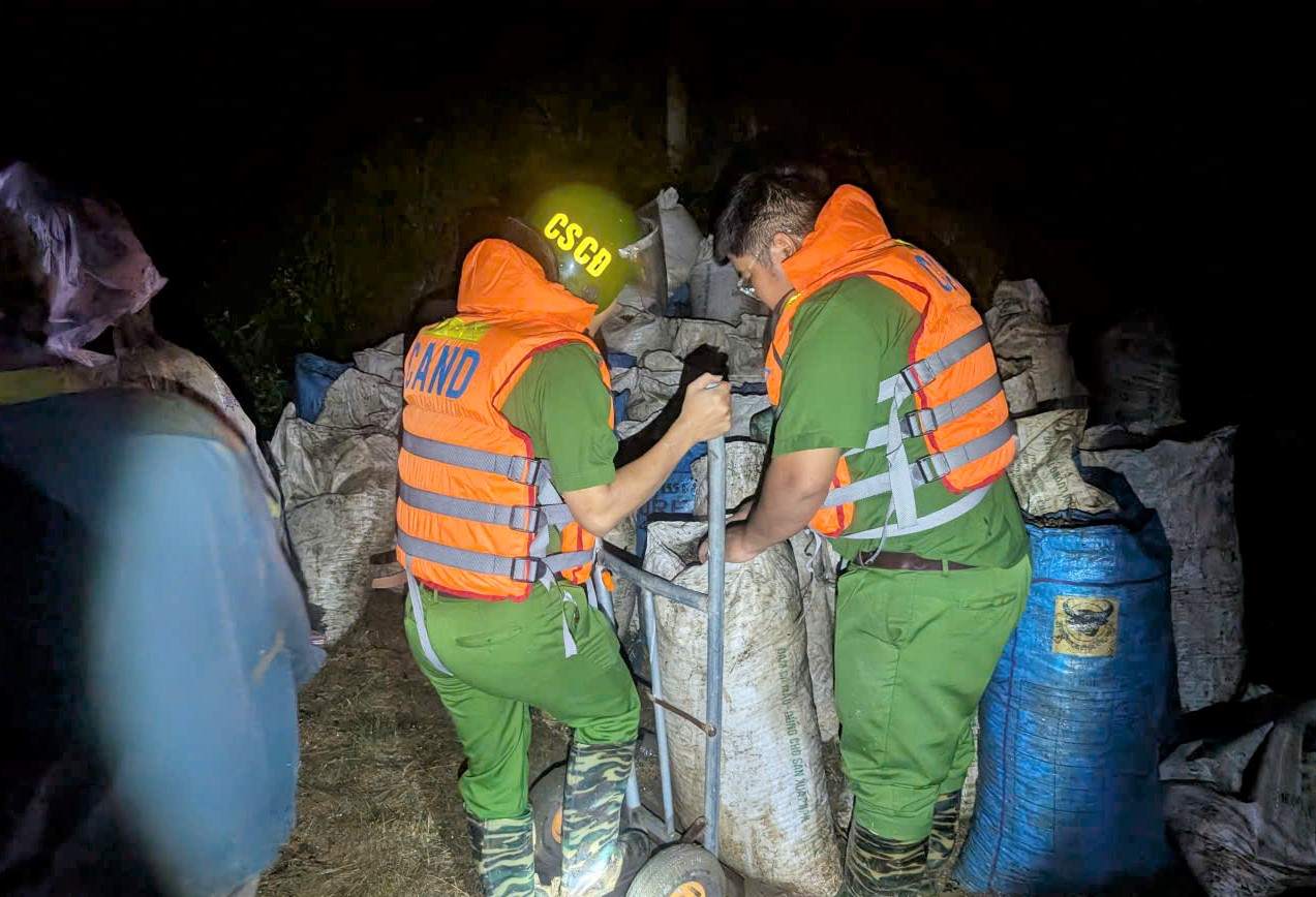 Las fuerzas policiales y milicias de la comuna de Lam Dong ayudan a la gente a retener cientos de sacos de cafe en riesgo de ser arrastrados por las inundaciones. Foto: Proporcionada por la policia