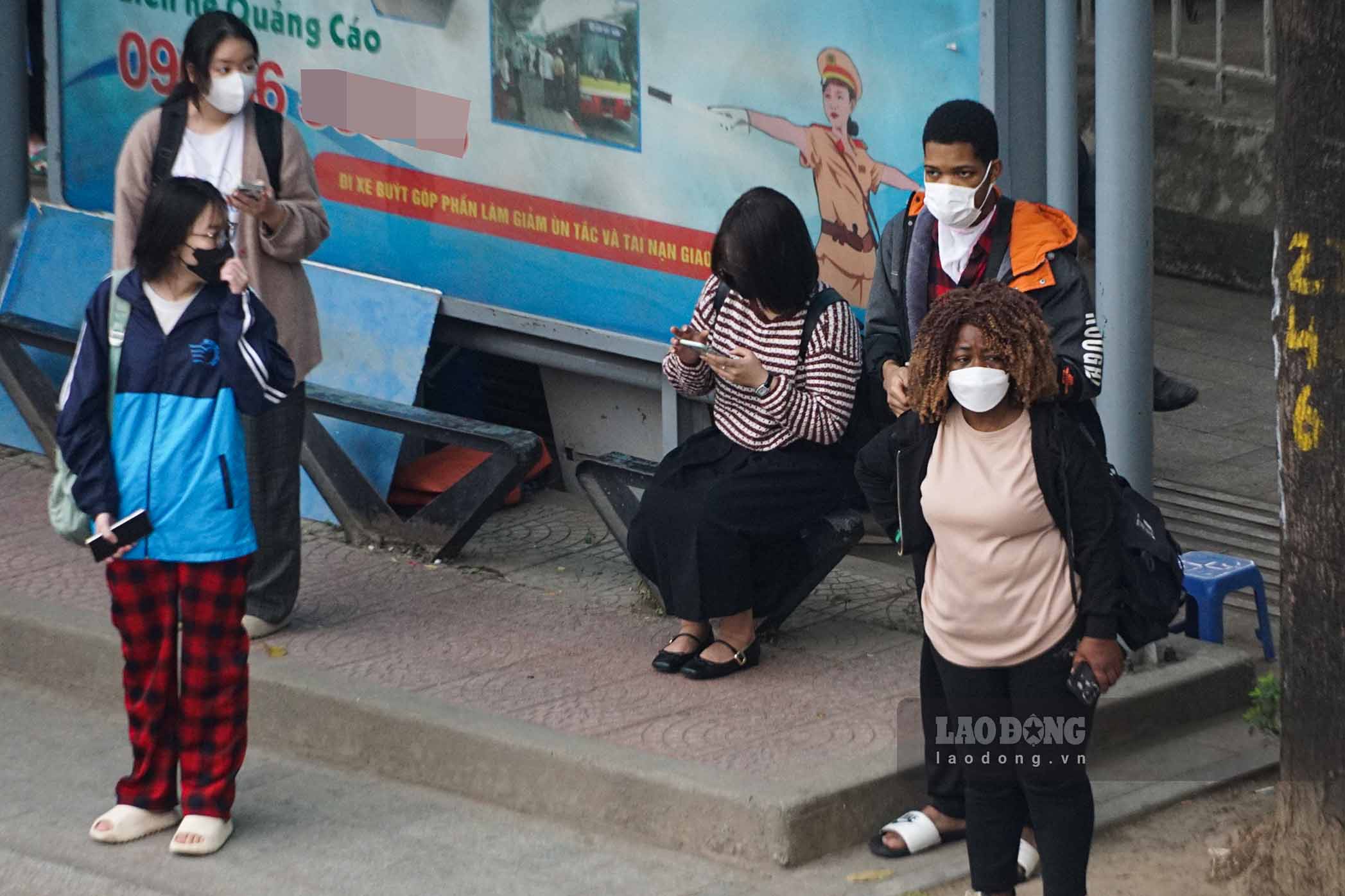 Hinh anh nguoi dan bit khau trang kin mit khi cho xe buyt tren duong Nguyen Chi Thanh.