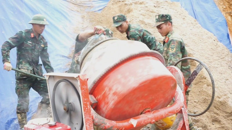 군인들이 비를 맞으며 산을 넘어 다낭 시민들이 설날을 맞이할 수 있도록 집을 짓습니다