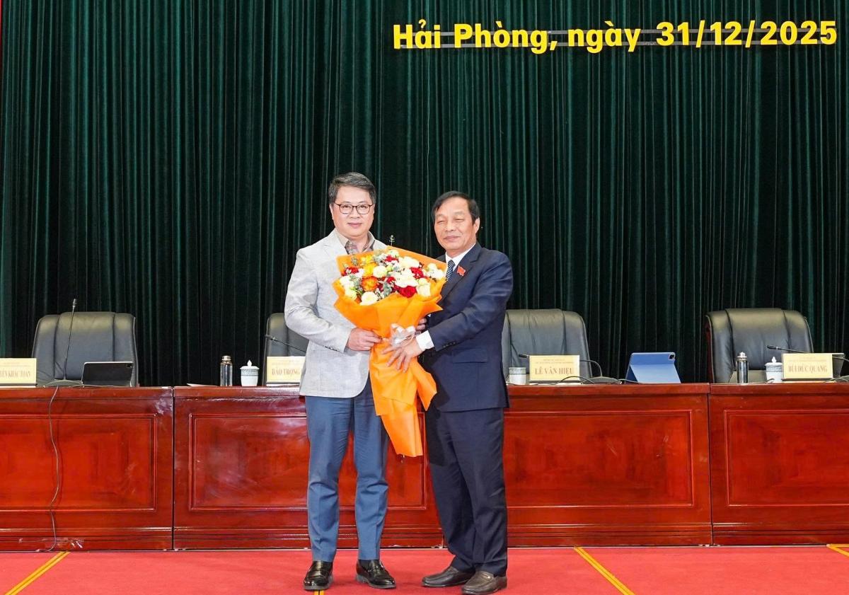레반히에우 시 인민의회 의장이 응우옌탄흥 건설부 국장에게 꽃다발을 전달하고 축하하고 있습니다. 사진: 하이퐁시 정보통신부