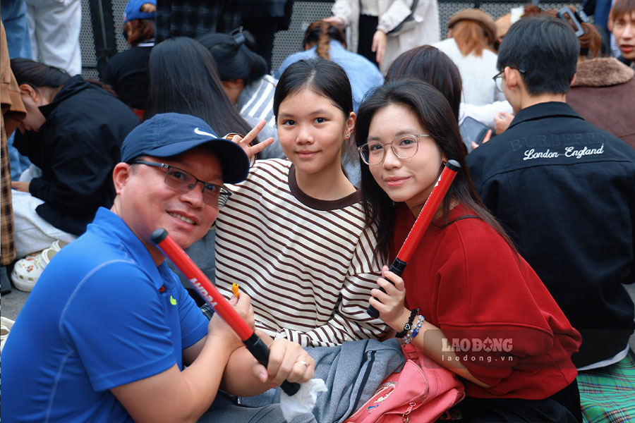 Gia dinh ban Vu Ngoc Bao Chau (phuong Vinh Tuy, Ha Noi) co mat tu 15h, mang theo do an, nuoc uong va tham ngoi de cho don dem nhac chao nam moi. Theo Bao Chau, gia dinh may man chon duoc vi tri thuan loi, vua theo doi chuong trinh am nhac, vua ngam phao hoa thoi khac giao thua.