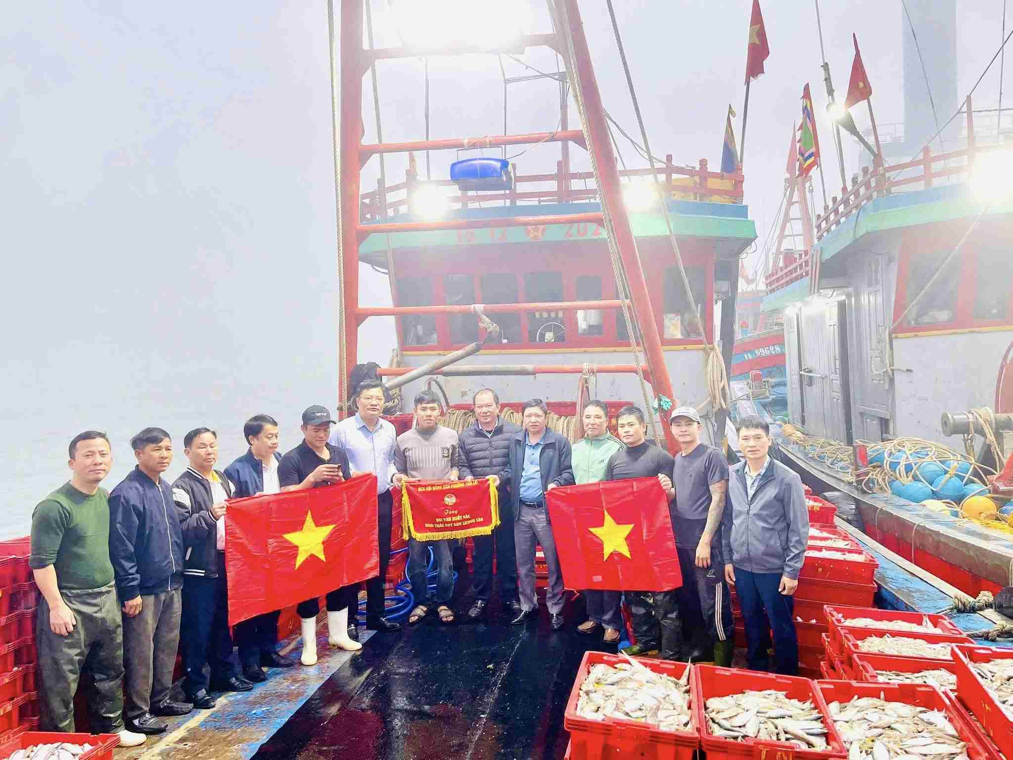 Mr. Ngo Duc Kien - Member of the Executive Committee of the Nghe An Provincial Party Committee, Secretary of the Party Committee, Chairman of the People's Council of Cua Lo ward - presented emulation flags to fisherman Nguyen Van Thanh's fleet with a output of 5.5 tons of seafood. Photo: Dinh Hung
