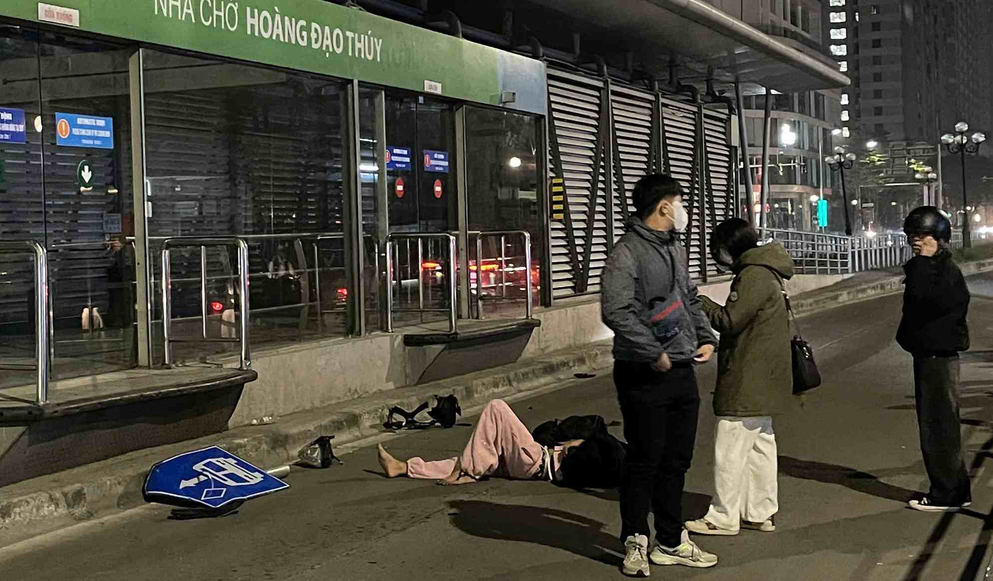 Nan nhan nam bat dong tren mat duong, duoc nguoi dan va luc luong chuc nang ho tro. Anh: Minh Vu