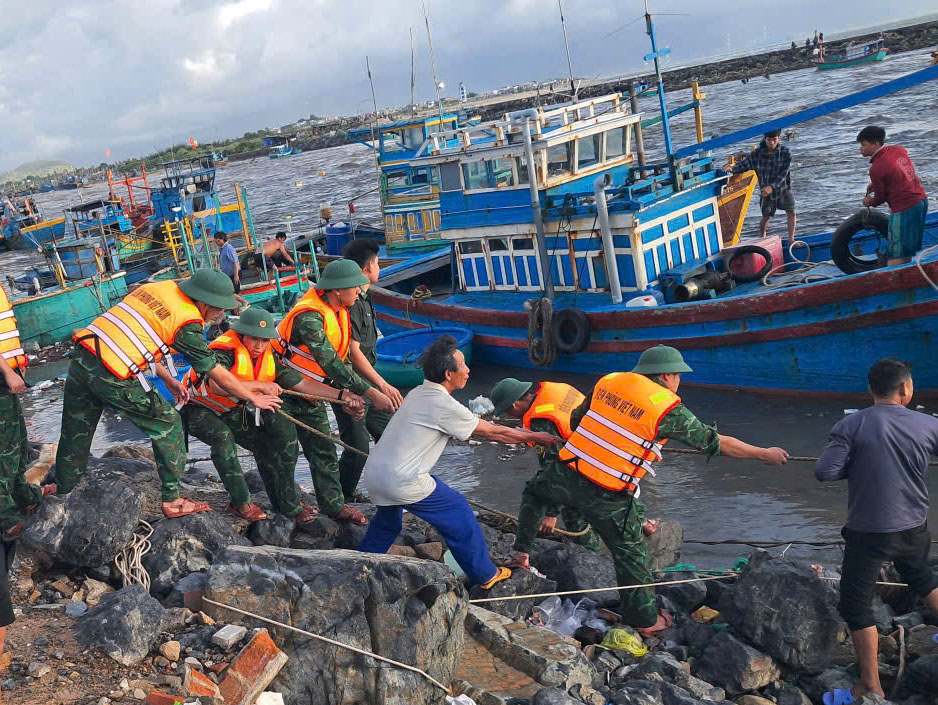 간부와 리엔흐엉 국경 수비대 군인들이 어부들이 홍수 수위 상승에 대비하여 안전하게 장비를 묶는 것을 돕고 있습니다. 사진: 반호안