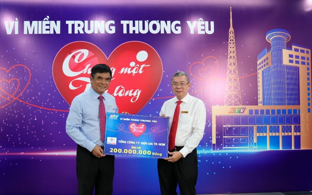 EVNHCMCのグエン・ヴァン・タイン総支配人(右)が、「Chung mot tam long: Vi mien Trung thuong yeu」基金への2億ドンの寄付金の象徴パネルを授与。写真:EVNHCMC提供.