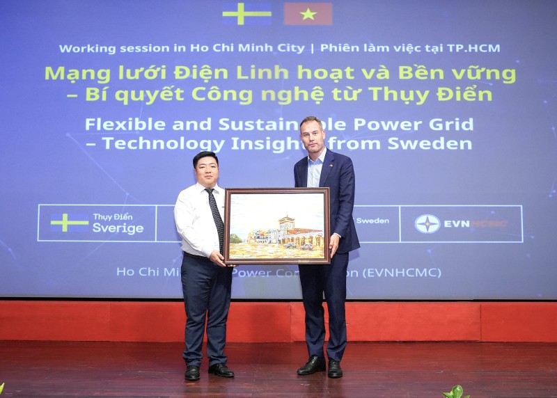 EVNHCMC 지도부 대표(왼쪽)가 스웨덴 대표단에게 기념품을 선물하고 있습니다. 사진: EVNHCMC 제공