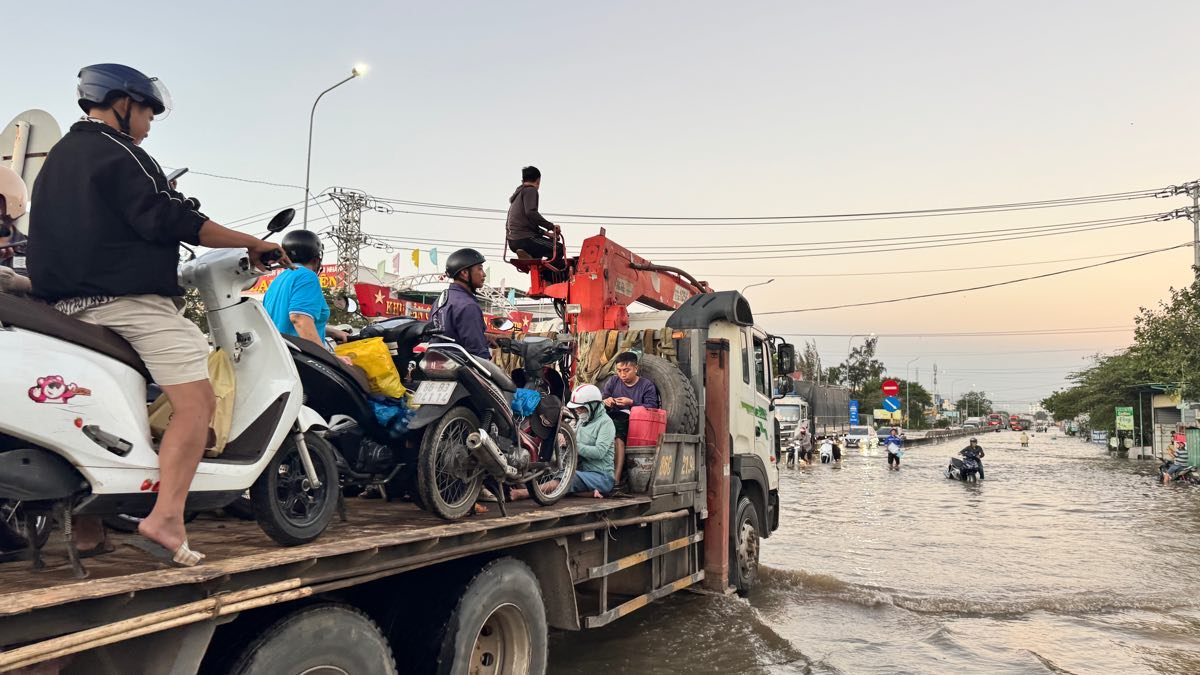 Xe cau ho tro dua xe may va nguoi dan qua vi tri ngap. Anh: Duy Tuan