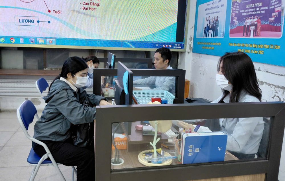 ハノイ雇用サービスセンターの職員が失業者向けの職業訓練政策を相談。写真:Quynh Chi