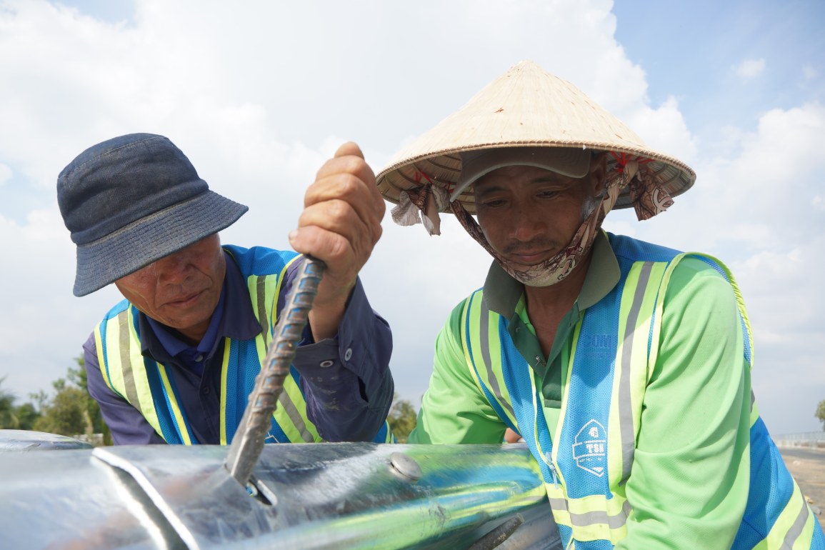 Cong nhan thi cong hang muc lap dat cau kien an toan giao thong. Anh: Ta Quang