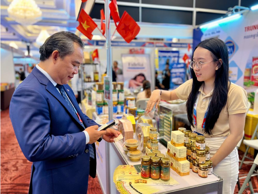 Huong dan cho vi khach nguoi Campuchia quet ma QR de xem them thong tin san pham cua cong ty bang tieng Anh. Anh: Thien Thanh