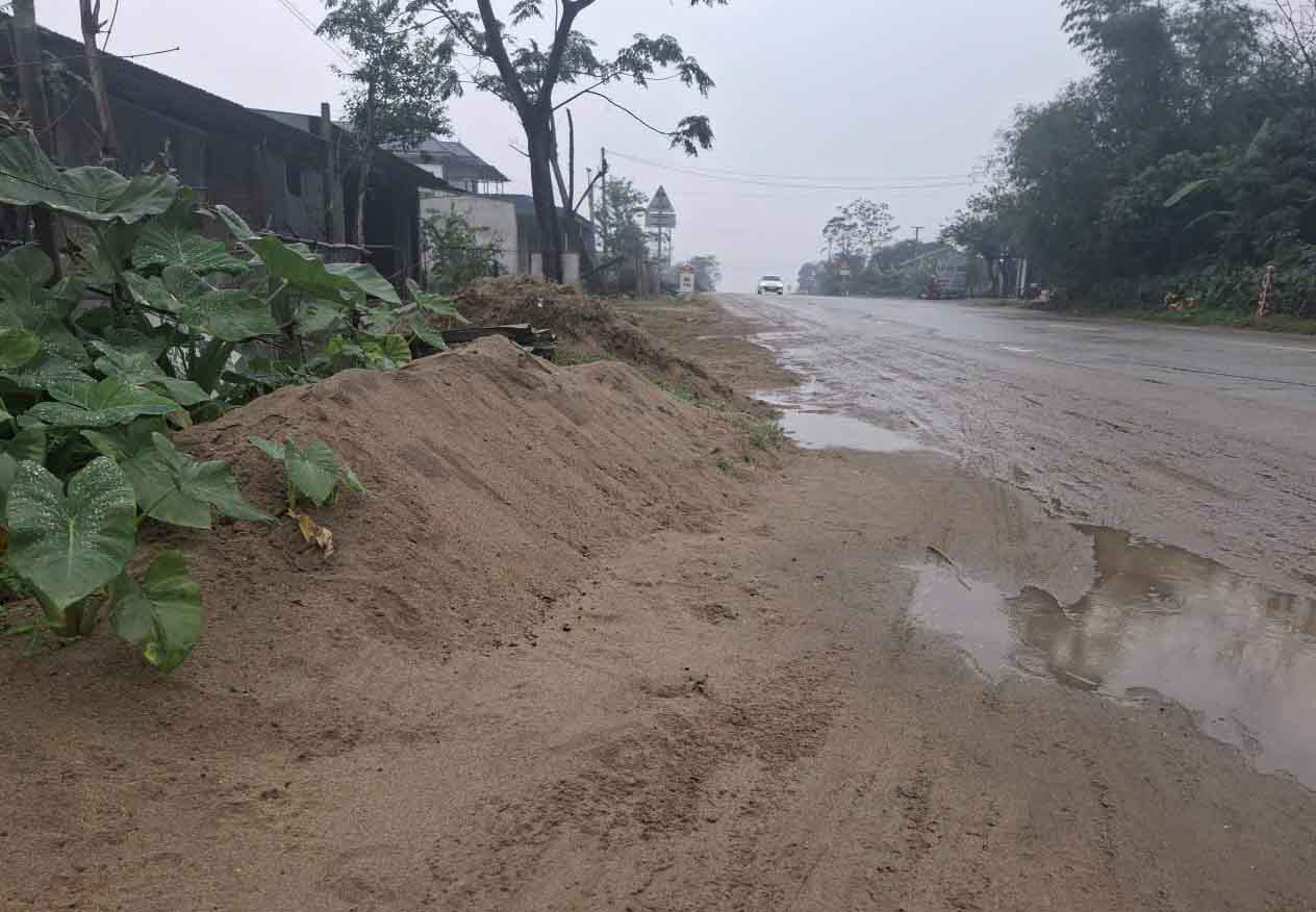Hàng ngày cát vương vãi trên Quốc lộ 1 trước nhà dân được dồn lại thành đống cao. Ảnh: Trần Tuấn.
