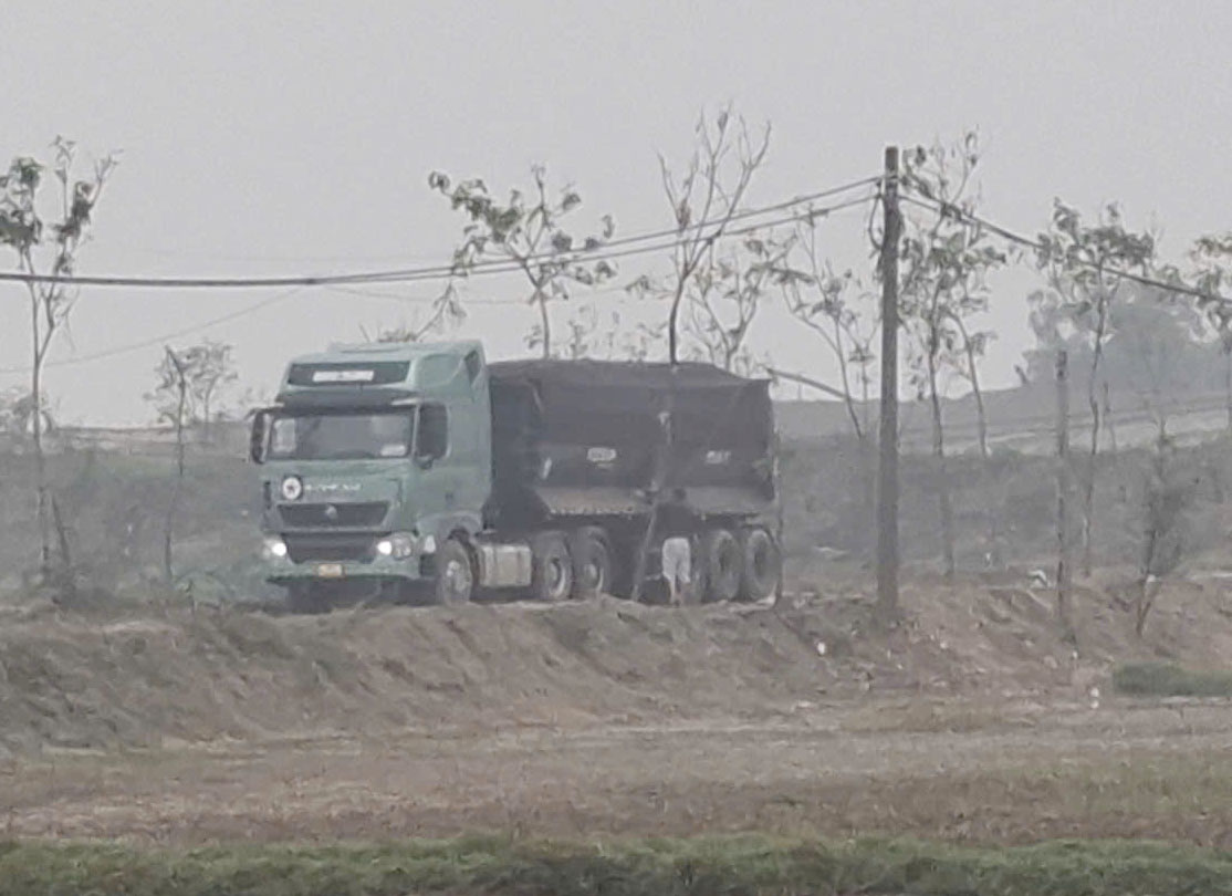 Xe chở cát từ bãi tập kết di chuyển ra Quốc lộ 1. Ảnh: Trần Tuấn.