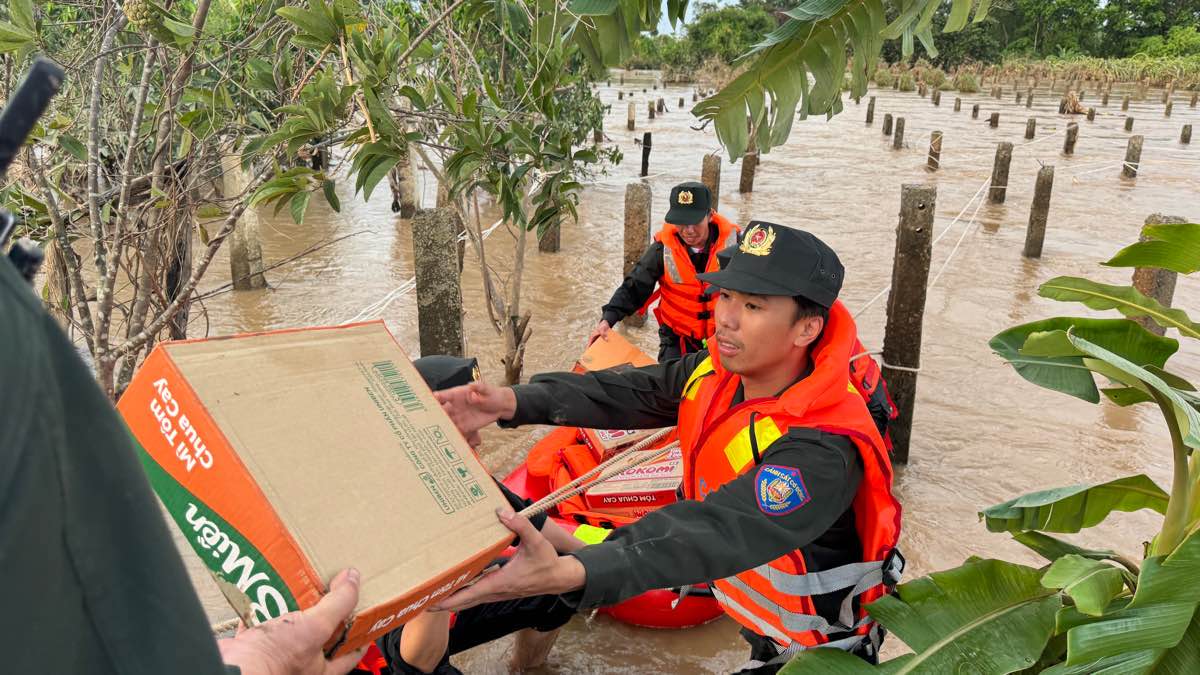 Lực lượng Cảnh sát Cơ động Công an tỉnh Lâm Đồng mang thực phẩm qua cho người dân bên kia bờ sạt lở. Ảnh: Duy Tuấn 