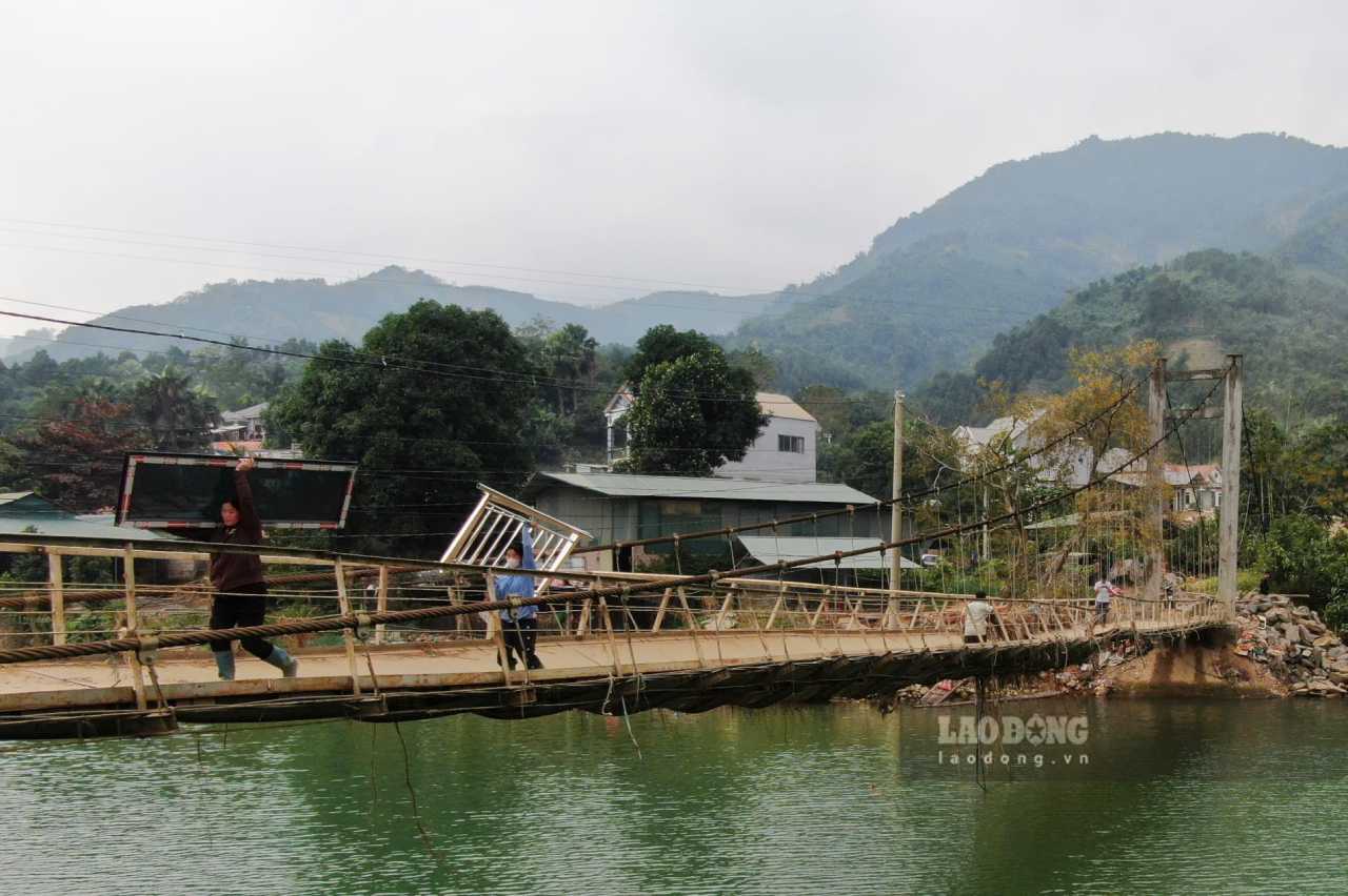 Nguoi dan phai lieu minh van chuyen vat lieu qua cau de sua chua nha cua. Anh: Van Duc