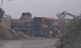 Heavy trucks carrying sand are scattered along National Highway 1 in Ha Tinh. Photo: Tran Tuan