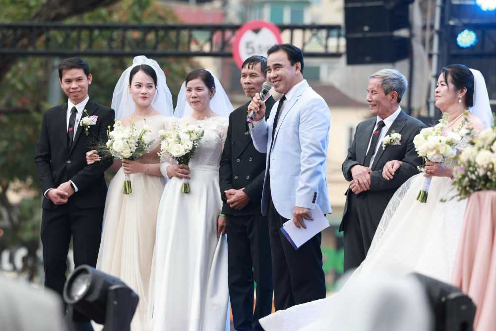 Vợ chồng anh Tùng bất ngờ khi bố mẹ cũng tham gia đám cưới tập thể. Ảnh: Hải Nguyễn