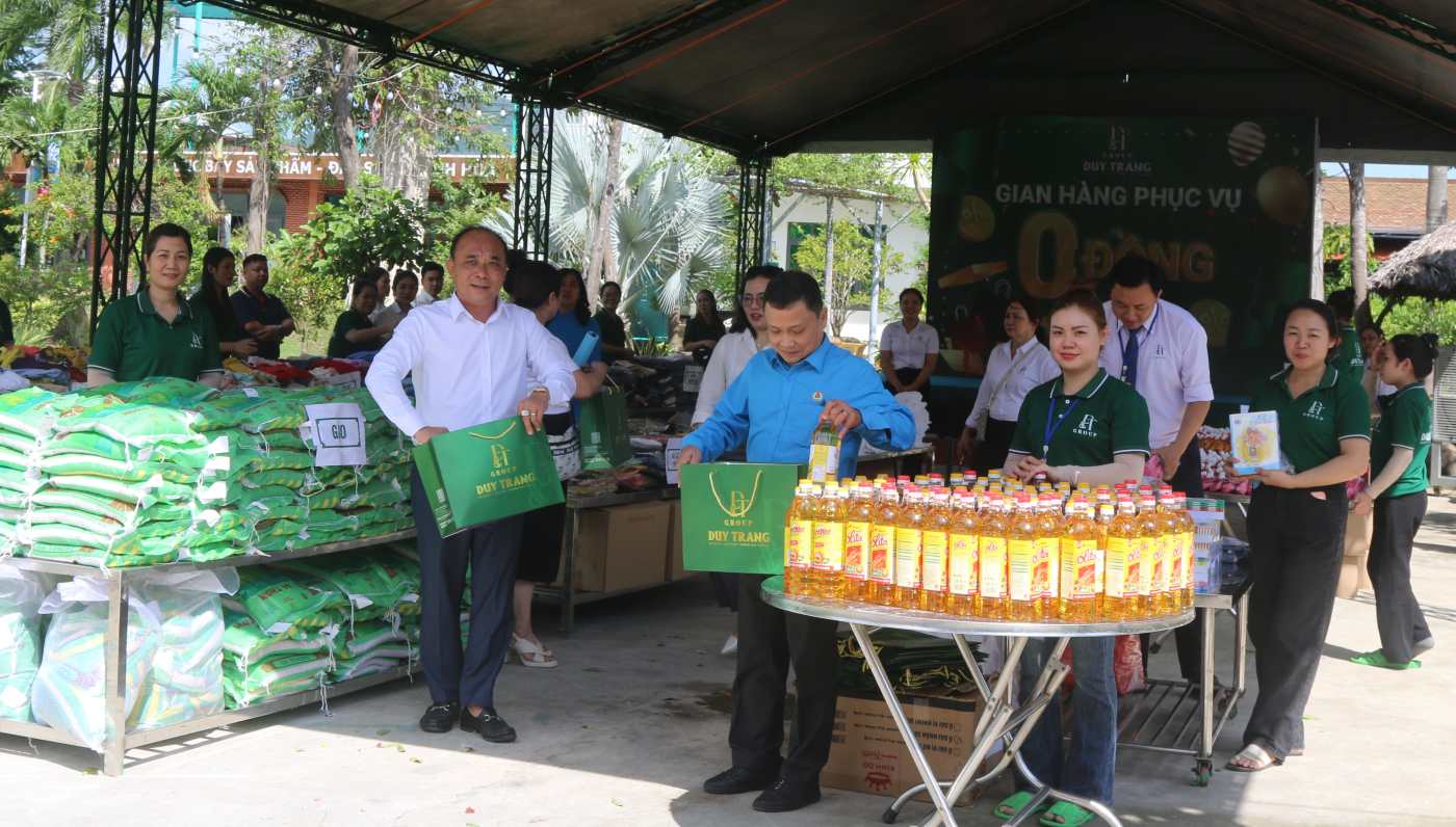 Lanh dao doanh nghiep va cong doan phat tui giay de doan vien kho khan sau lu mang phieu di cho 0 dong. Anh: Phuong Linh