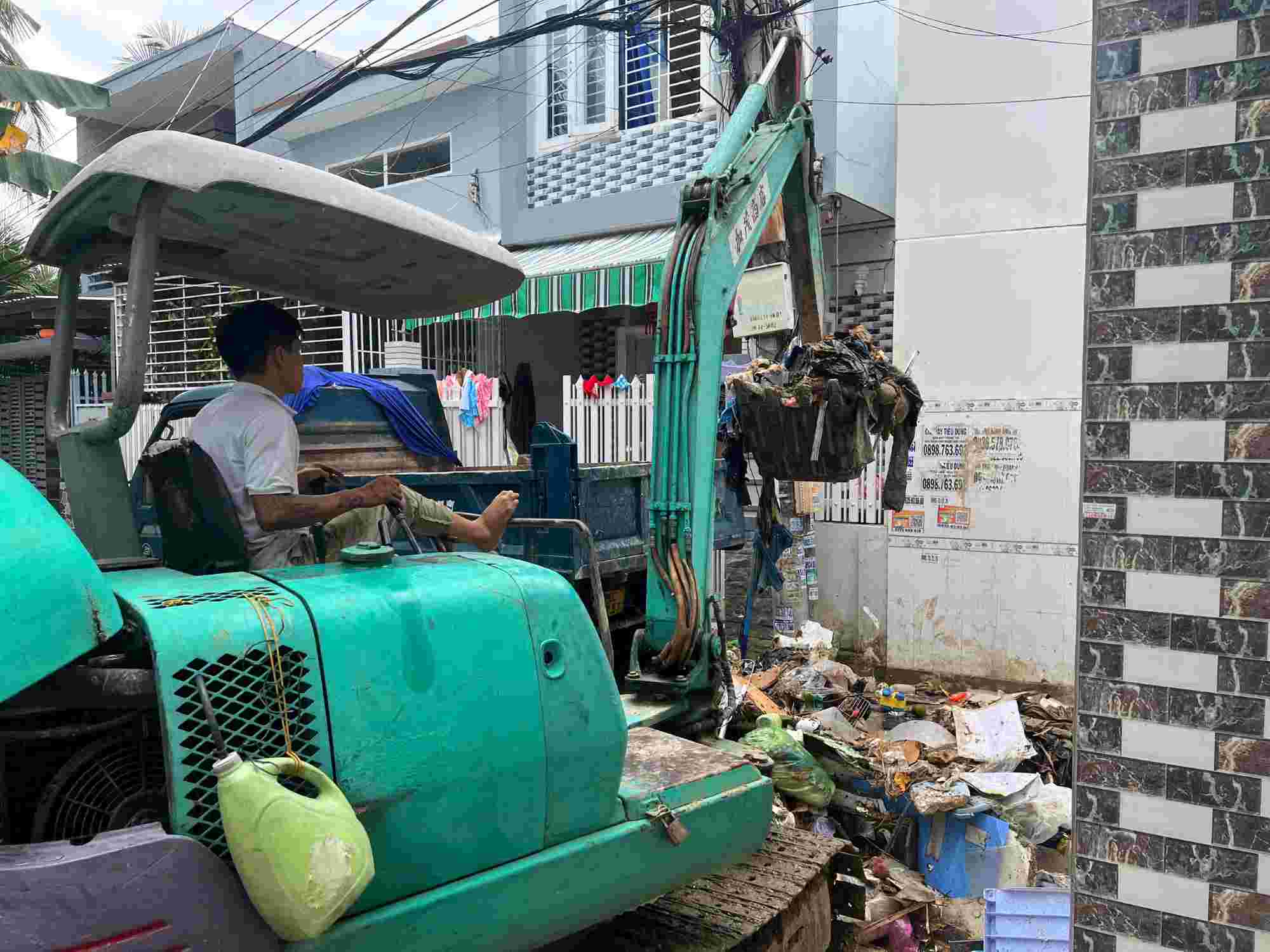 Los camiones de recogida de basura son alquilados por la gente del grupo 4 Ngoc Hoi para recoger basura y prevenir epidemias despues de las inundaciones. Foto: Phuong Linh