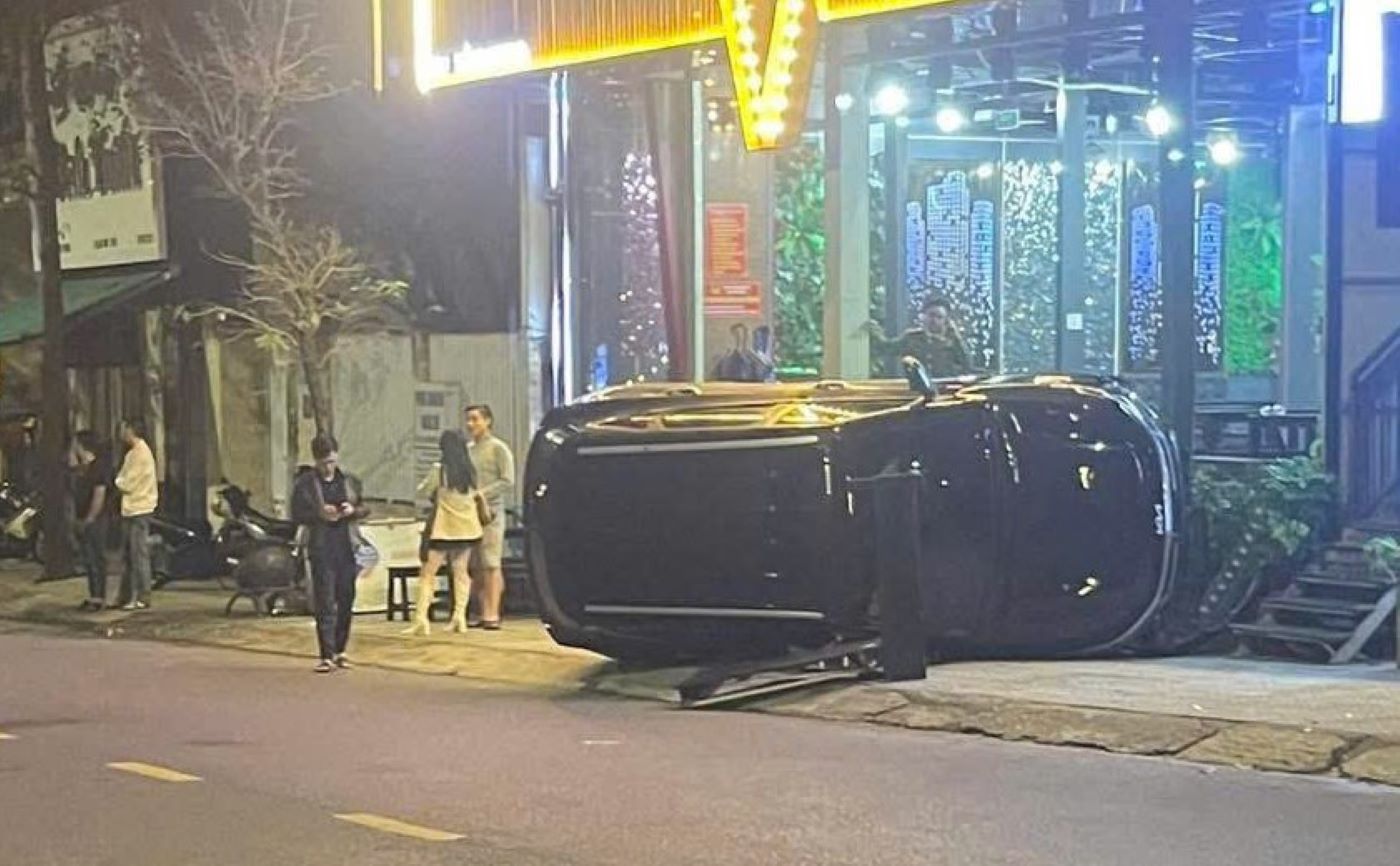 Chiếc xe ô tô đâm vào nhóm người đứng trên vỉa hè rồi lật nghiêng. Ảnh: H.Nguyên