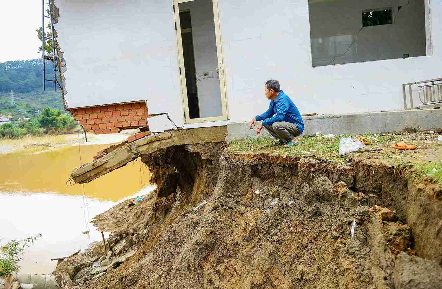Ong Tran Pho Tau (xa D'ran) ngoi than tho ben can nha nut toac cho sap do bo song Da Nhim sat lo nghiem trong. Anh: Phuc Khanh