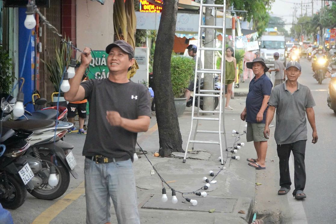 Người dân lắp đặt đèn trên đường Phạm Thế Hiển. Ảnh: Nguyên Chân