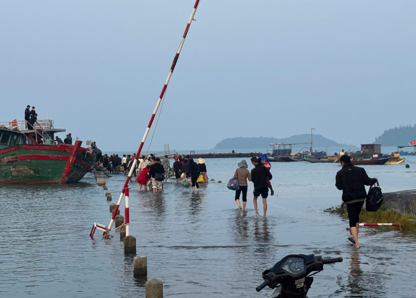 Du khach va nguoi dan loi nuoc tren cau cang Quan Lan. Anh: Nguyen Hung