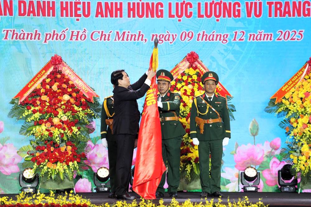 Chu tich nuoc Luong Cuong gan huy hieu Anh hung LLVT nhan dan len Quan ky Quyet thang Quan khu 7. Ảnh: Nguyen Tien
