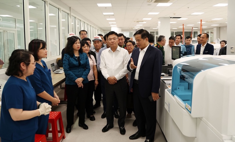 PGS.TS Dao Xuan Co bao cao voi Pho Thu tuong Chinh phu Le Thanh Long va Bo truong Bo Y te Dao Hong Lan tai mot phong xet nghiem cua co so 2 Benh vien Bach Mai. Anh Duc Tuan