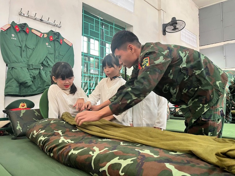 Hoc sinh duoc chien si bo doi huong dan gap chan, man. Anh: Van Trang