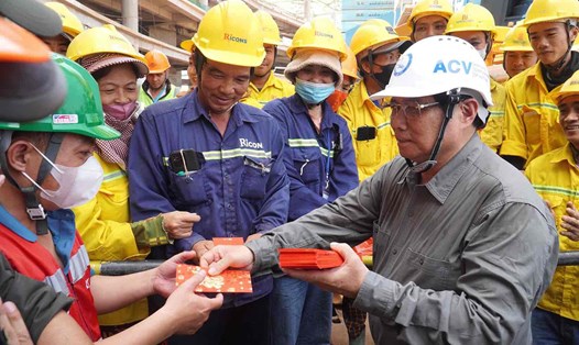 Thủ tướng Chính phủ Phạm Minh Chính lì xì đầu năm mới cho công nhân đang thi công xuyên Tết tại nhà ga hành khách sân bay Long Thành. Ảnh: HAC