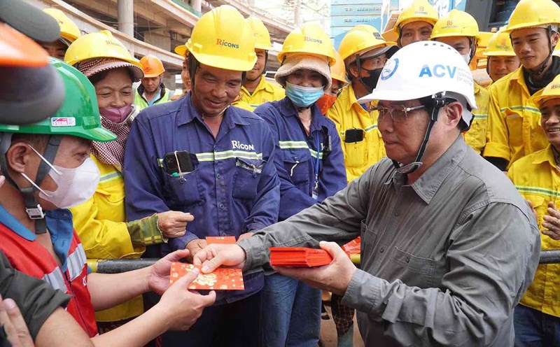 Prime Minister Pham Minh Chinh gives New Year's lucky money to workers who are working through Tet at the passenger terminal of Long Thanh airport. Photo: HAC