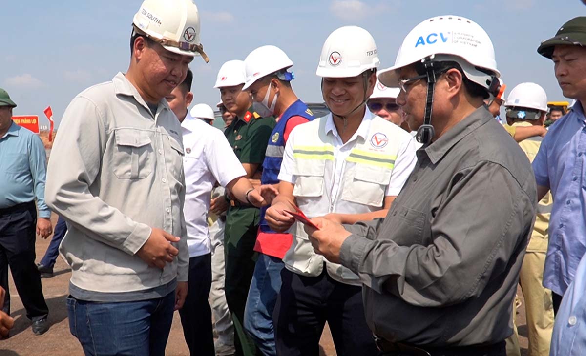 Prime Minister Pham Minh Chinh gives lucky money to workers working during Tet at Long Thanh airport. Photo: HAC