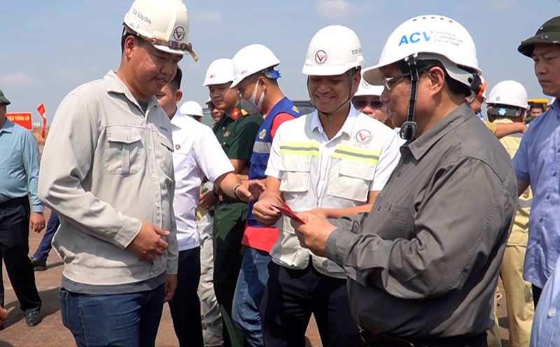 Prime Minister Pham Minh Chinh gives lucky money to workers working during Tet at Long Thanh airport. Photo: HAC