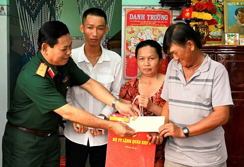 Major General Quach Van Nho, Deputy Commander of Military Region 9, presents gifts to families of young men who will join the army in 2025 in Phuoc Long district, Bac Lieu province. Photo: Nhat Ho