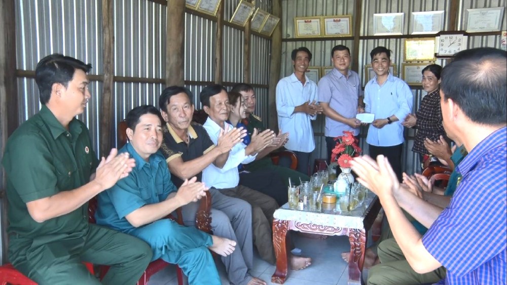 Ban Chi huy Quan su huyen An Minh va chinh quyen dia phuong den gap go gia dinh va thanh nien Nguyen Minh Dau. Anh: Xuan Nhi
