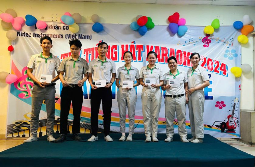 Ms. Truong Thi Kieu Nhu (right cover) presented the award for the singing contest organized by the Trade Union of Nidec Instruments Vietnam Co., Ltd. Photo: Duc Long