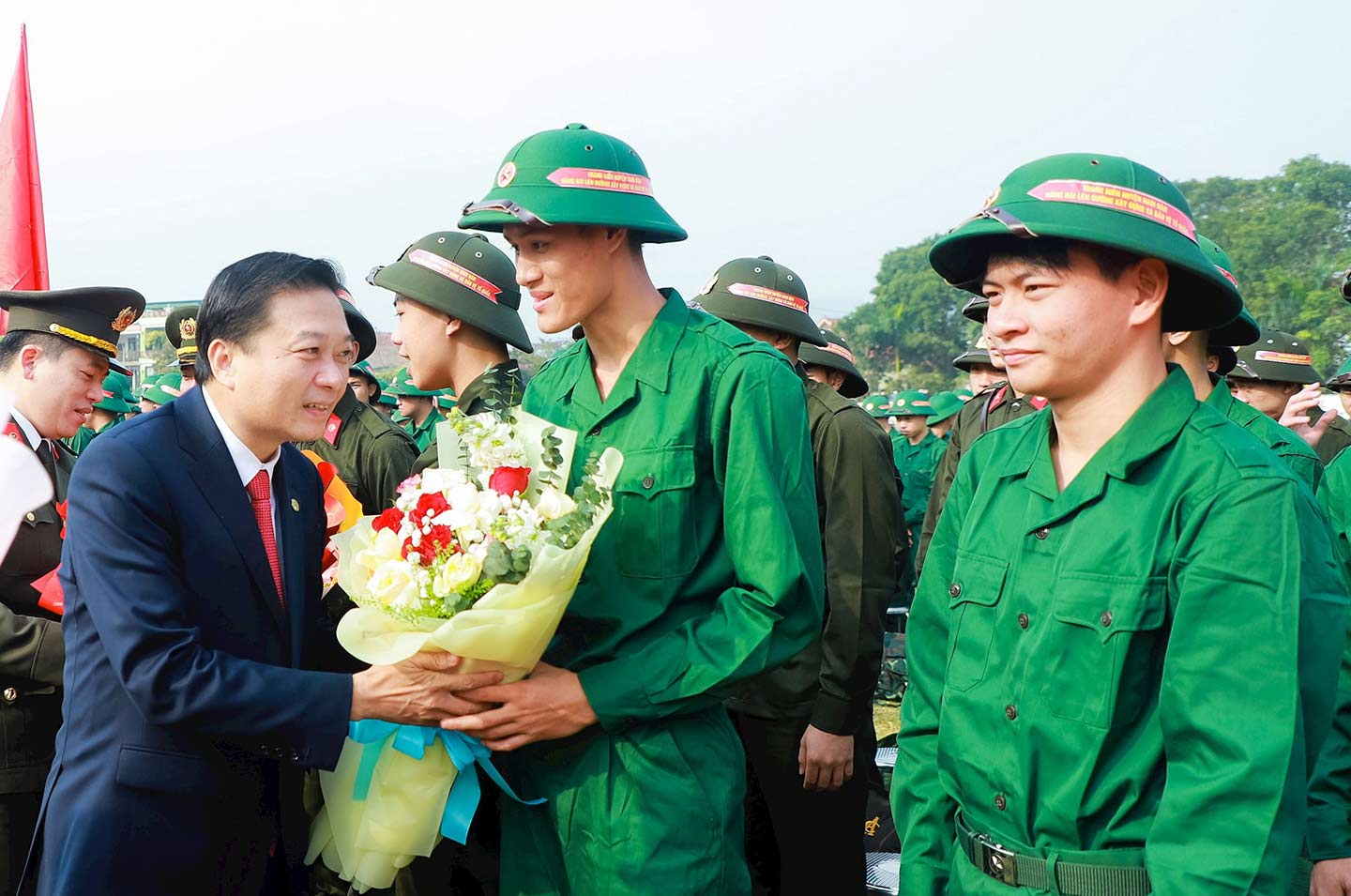 Ông Lê Hồng Vinh - Phó Bí thư Tỉnh ủy, Chủ tịch UBND tỉnh, Chủ tịch Hội đồng Nghĩa vụ quân sự tỉnh Nghệ An tặng hoa chúc mừng tân binh. Ảnh: Thành Duy